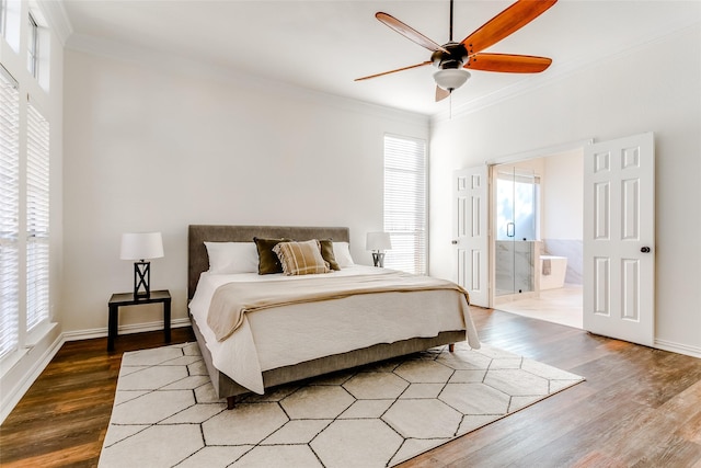 bedroom with hardwood / wood-style floors, ensuite bathroom, ceiling fan, and multiple windows