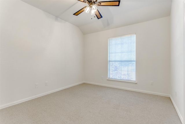 empty room featuring ceiling fan, light carpet, and vaulted ceiling