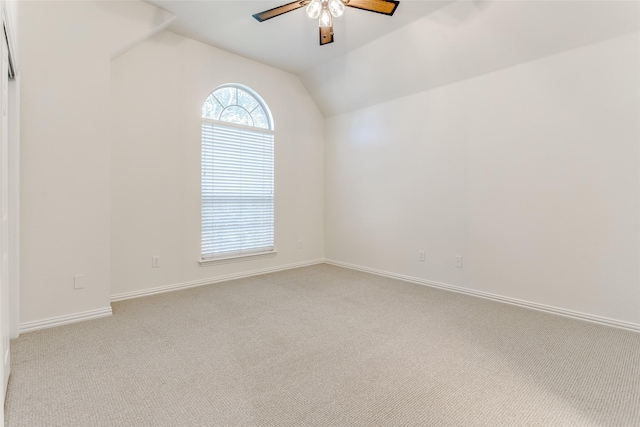 carpeted empty room with ceiling fan and lofted ceiling