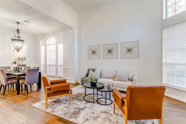 living room featuring crown molding, a chandelier, and hardwood / wood-style flooring