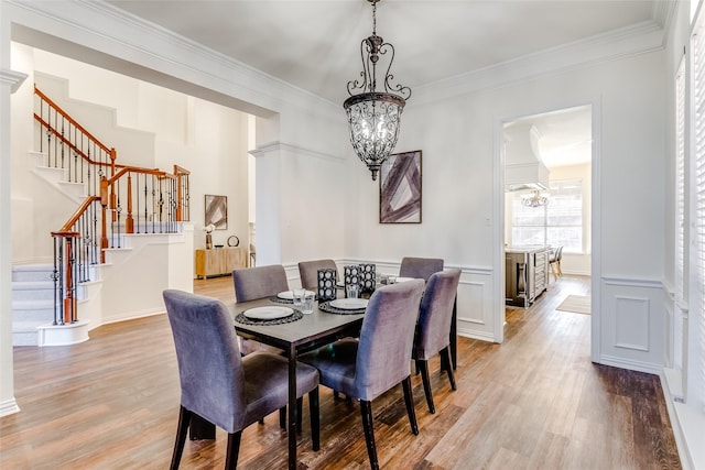 dining space featuring light hardwood / wood-style floors, crown molding, and a notable chandelier