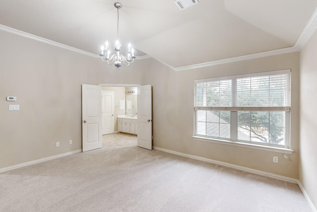 carpeted empty room featuring lofted ceiling, ornamental molding, and an inviting chandelier