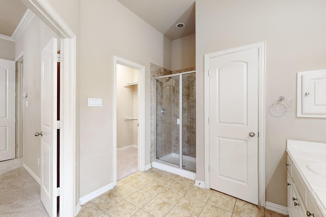 bathroom with tile patterned floors, vanity, crown molding, and walk in shower