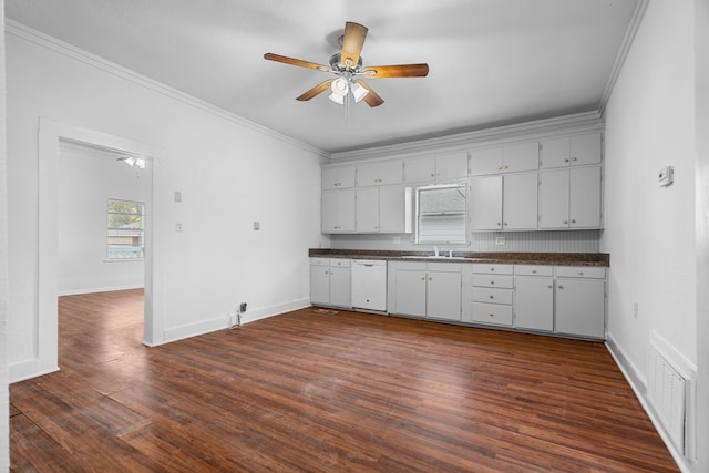 kitchen with white dishwasher, dark wood-type flooring, ornamental molding, and white cabinets