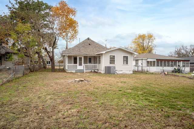 back of house with a lawn, a sunroom, cooling unit, and covered porch