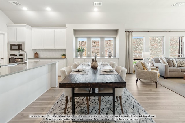 dining space with light hardwood / wood-style floors and sink