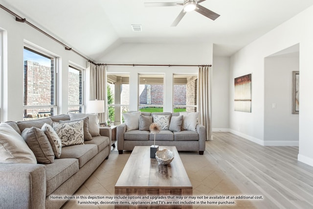 living room with ceiling fan, a healthy amount of sunlight, light wood-type flooring, and vaulted ceiling