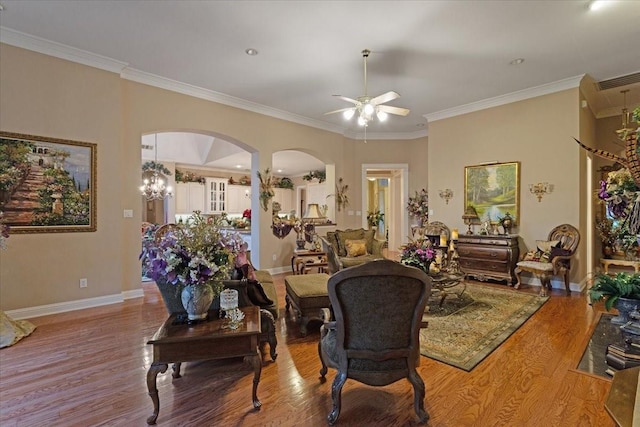 dining area with light hardwood / wood-style floors, ceiling fan with notable chandelier, and ornamental molding