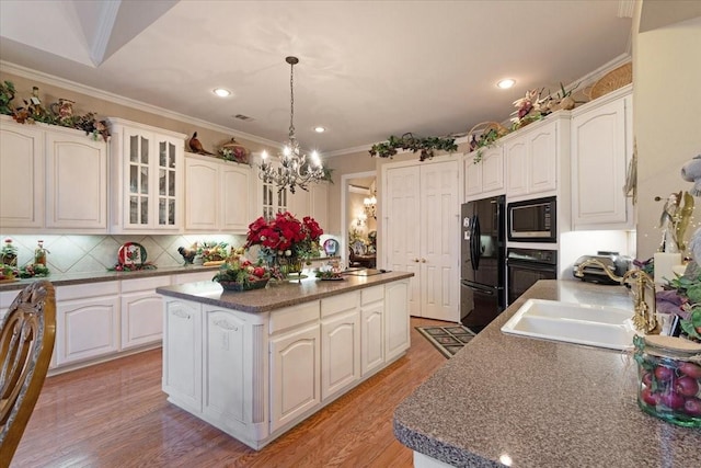 1305 Bentbrook Ln, Sherman, TX 75092 - kitchen with black appliances, a chandelier, a center island, glass insert cabinets, and white cabinets