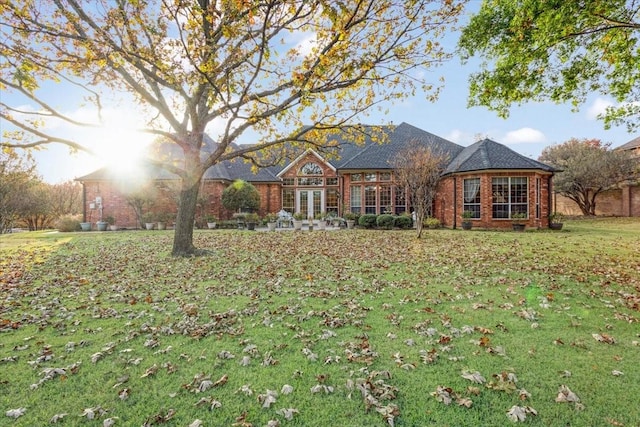 ranch-style house featuring a front yard and french doors