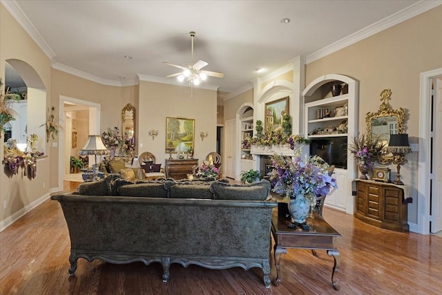 living room with hardwood / wood-style floors, ceiling fan, and ornamental molding