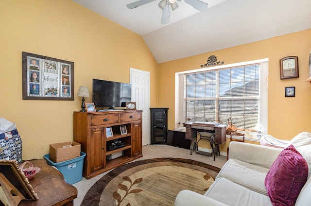 carpeted living room with ceiling fan and vaulted ceiling