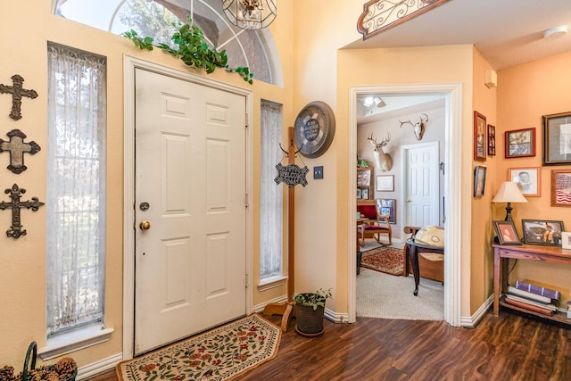 entryway with dark hardwood / wood-style flooring and a notable chandelier