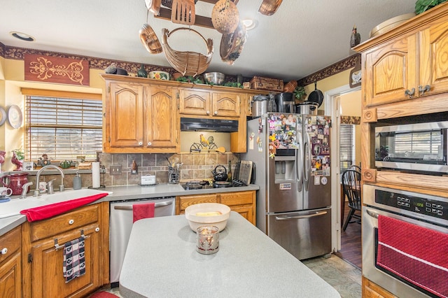 kitchen featuring decorative backsplash, sink, and appliances with stainless steel finishes