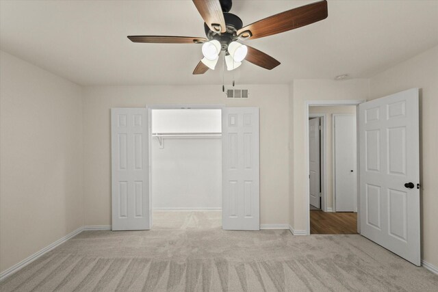 unfurnished bedroom featuring ceiling fan, a closet, and light carpet