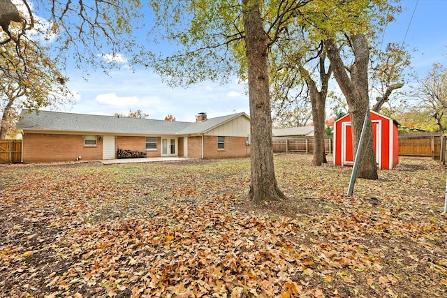 rear view of property featuring a storage unit