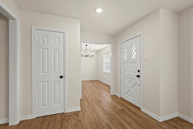 entrance foyer featuring light wood-type flooring and a notable chandelier