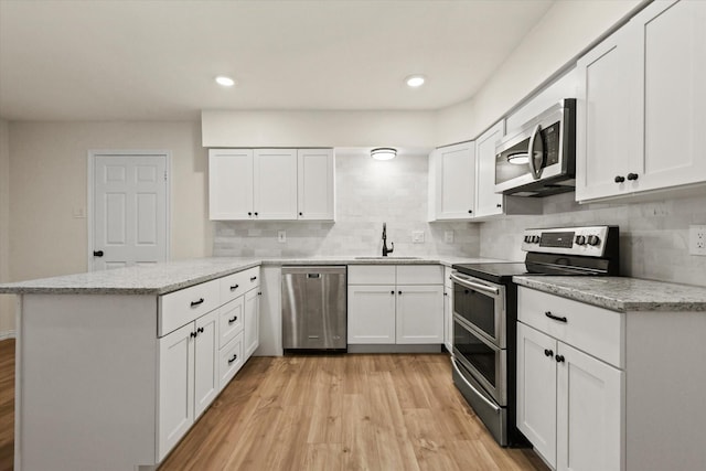 kitchen featuring light hardwood / wood-style floors, white cabinetry, sink, and appliances with stainless steel finishes