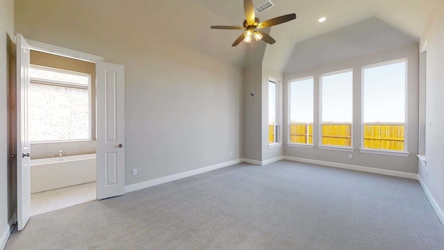 spare room with ceiling fan, light colored carpet, a healthy amount of sunlight, and lofted ceiling