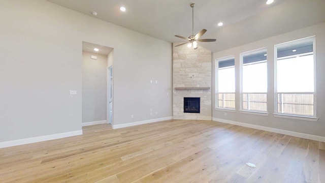 unfurnished living room featuring a fireplace, light hardwood / wood-style flooring, and ceiling fan