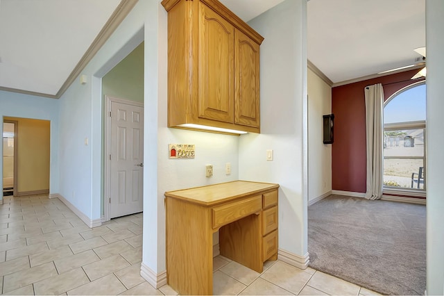 kitchen with ornamental molding and light carpet