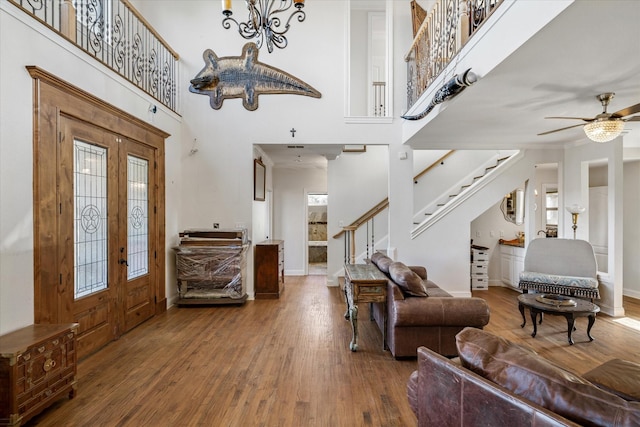 entrance foyer featuring ceiling fan, a towering ceiling, and wood-type flooring