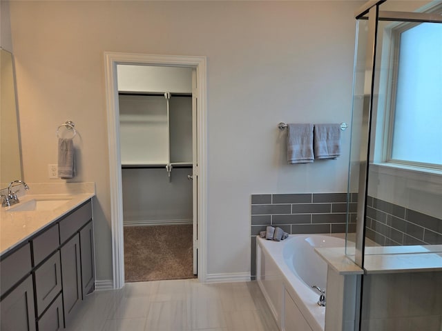 7220 Monarch Trl, Mckinney, TX 75071 - bathroom featuring a garden tub, a spacious closet, double vanity, baseboards, and a shower