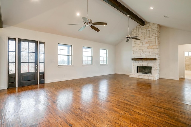 unfurnished living room with beamed ceiling, dark hardwood / wood-style floors, a stone fireplace, and ceiling fan