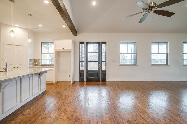 interior space featuring dark wood-type flooring, ceiling fan, light stone countertops, decorative light fixtures, and white cabinetry