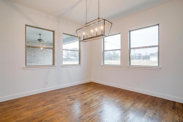 unfurnished room featuring hardwood / wood-style floors and ceiling fan with notable chandelier