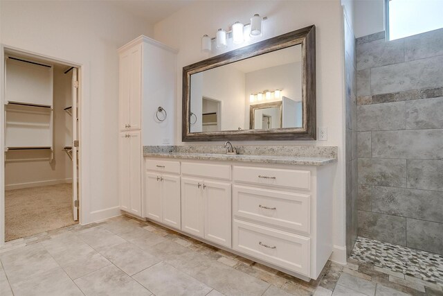 bathroom with vanity and a tile shower