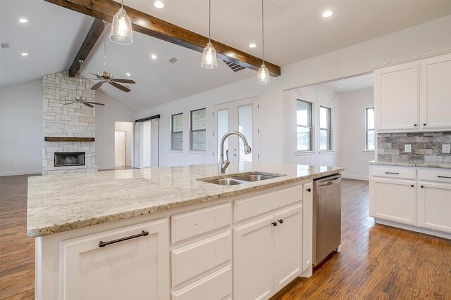 kitchen with dark hardwood / wood-style flooring, stainless steel dishwasher, sink, lofted ceiling with beams, and white cabinets