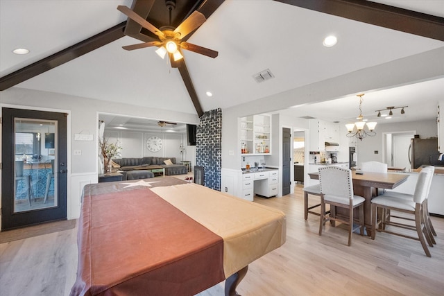 dining space with ceiling fan with notable chandelier, lofted ceiling with beams, and light hardwood / wood-style flooring