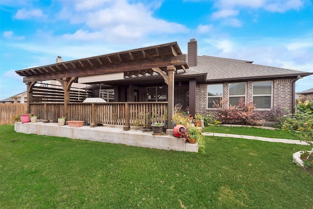 rear view of property featuring a pergola and a yard