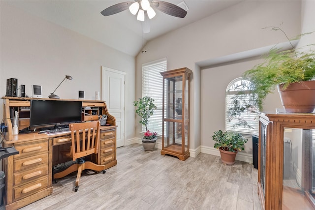 home office with ceiling fan, a healthy amount of sunlight, vaulted ceiling, and light hardwood / wood-style flooring