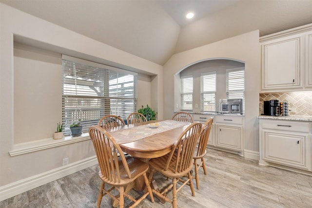 dining area with light hardwood / wood-style flooring and lofted ceiling