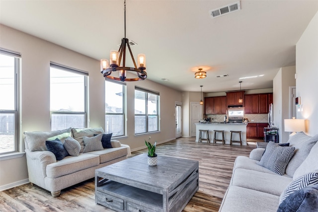 living room with a chandelier, plenty of natural light, and hardwood / wood-style floors