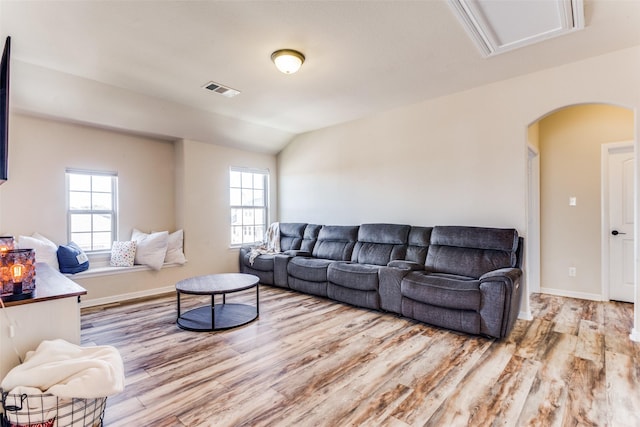 living room featuring light hardwood / wood-style flooring, a wealth of natural light, and vaulted ceiling