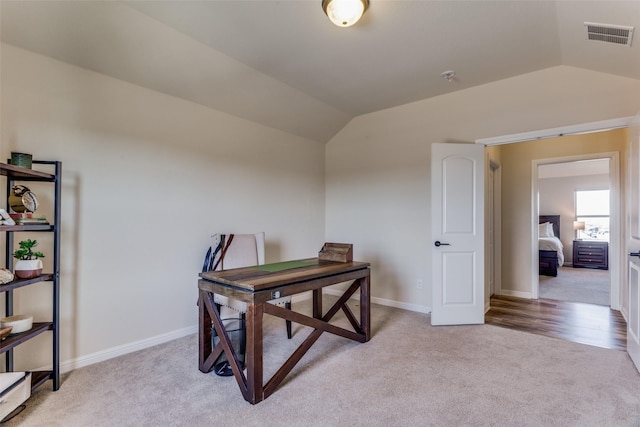 office space with light carpet and vaulted ceiling