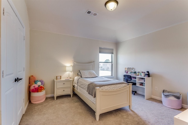 carpeted bedroom featuring a closet and lofted ceiling