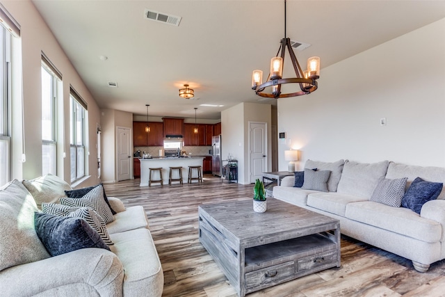 living room featuring hardwood / wood-style flooring and an inviting chandelier