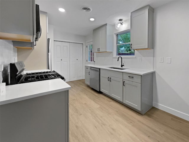 8512 Charing Cross Ln, Dallas, TX 75238 - kitchen featuring stainless steel appliances, gray cabinetry, decorative backsplash, light wood-type flooring, and light countertops