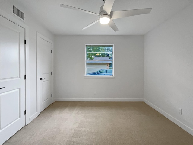 carpeted spare room with ceiling fan