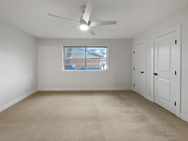 carpeted spare room with ceiling fan