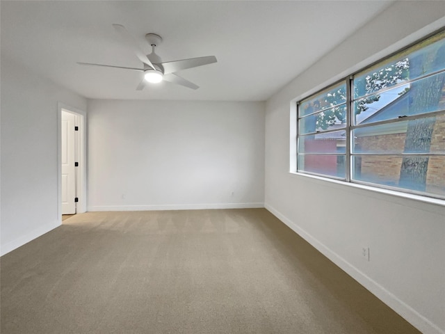 carpeted spare room featuring ceiling fan