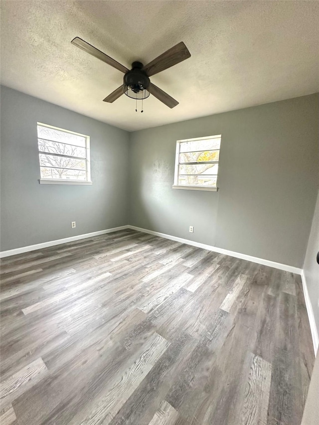 spare room with a textured ceiling, hardwood / wood-style flooring, and ceiling fan