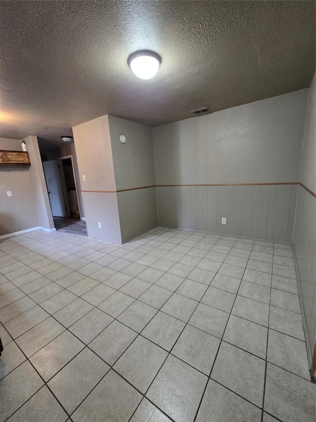 empty room featuring light tile patterned floors and a textured ceiling