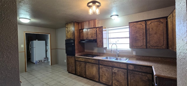 kitchen with dark brown cabinets, sink, black appliances, and a textured ceiling