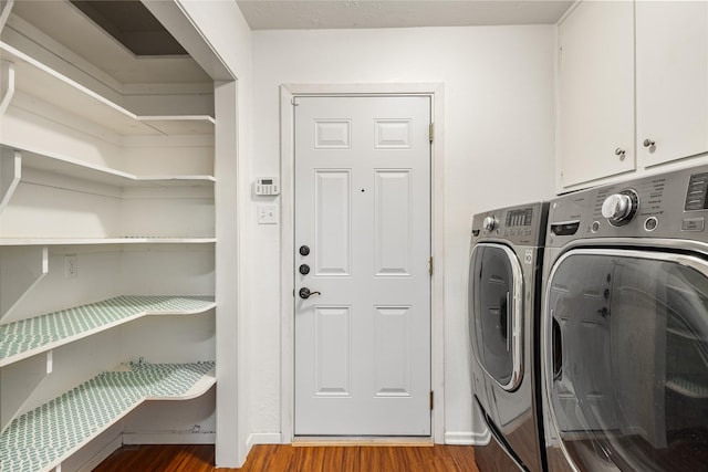 laundry room featuring cabinets, washer and clothes dryer, and light hardwood / wood-style flooring