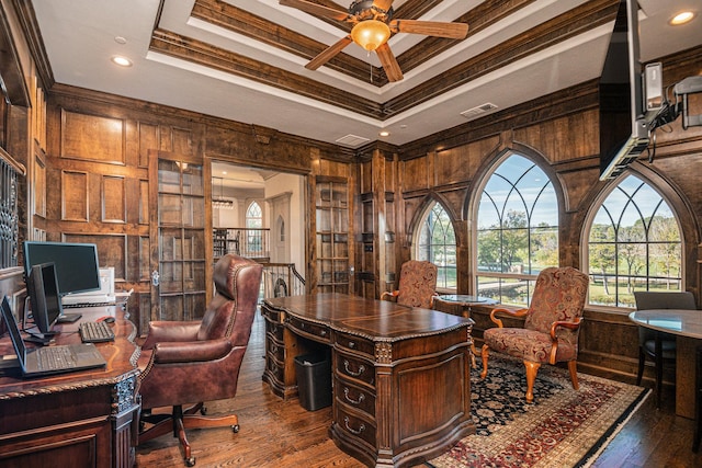 office space featuring a raised ceiling, ornamental molding, and hardwood / wood-style flooring